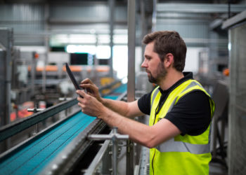 Factory worker using a digital tablet in factory